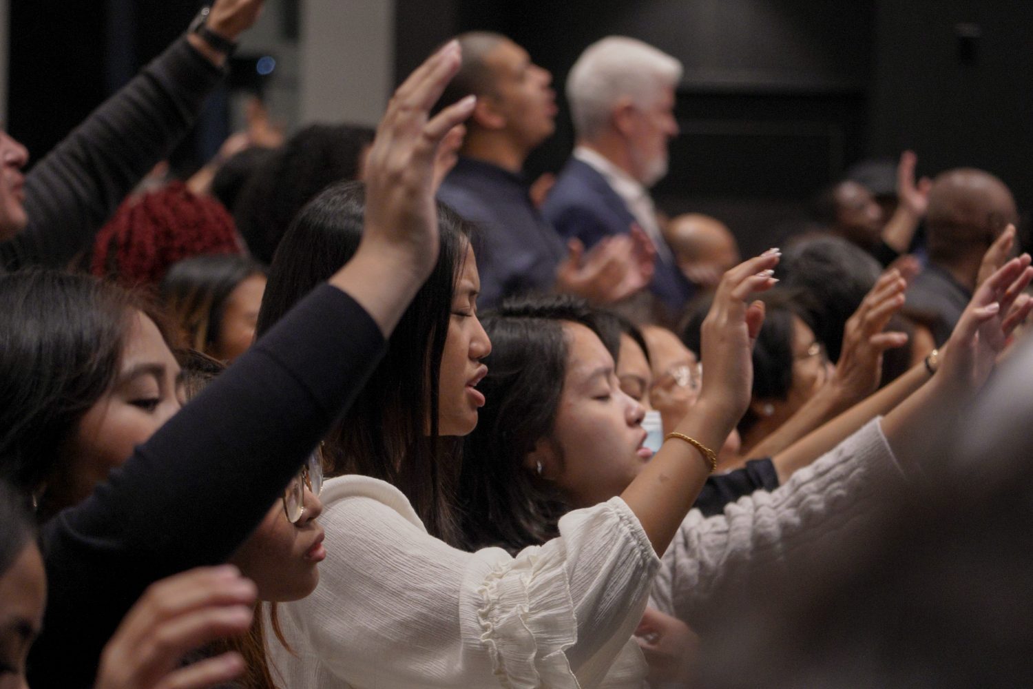 Congregation worshipping with lifted hands